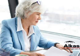 mulher idosa caucasiana de cabelos brancos e blazer azul claro mexendo em notebook