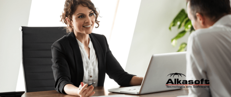 Mulher branca de cabelo cacheado utilizando computador e conversando com cliente